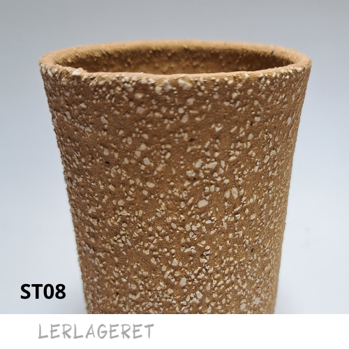 ST08 Den gule med chamotte fra lerlageret.com
En smuk grov stentøjsler, der er ideel til pladeteknik og modellering.
Er du øvet drejer, er ST08 utrolig lækker at dreje i. Hold skiven ren for chamotte under centrering, så du ikke ødelægger fingrene, i optræk er den fantastisk.
Når ST08 er tør eller læderhård kan den vaskes med en vreden svamp, det fremhæver chamotten og laver en spændende struktur. Chamotten er hvid/lysegul.
ST08 er rød frem til sidste brænding og bliver efter brænding gul/orange.